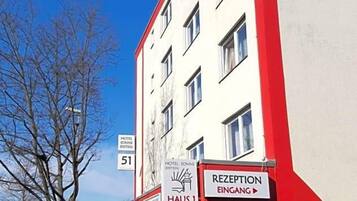 Ein Hotelgebäude mit einer Rezeption und einem Schild, das Zimmer Nummer 51 anzeigt.