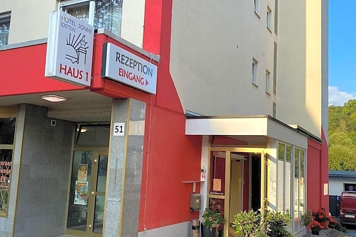 A hotel entrance with a reception desk and a sign indicating the hotel name.