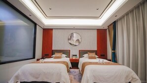 A hotel room with two beds, a large mirror, a TV, and a window. - Yue Feng Yuan Hotel (Fengkai)