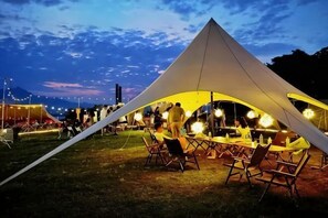 Una carpa grande con un comedor, mesas y sillas.