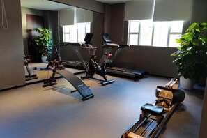A gym with exercise equipment, a treadmill, and a bench. - Yue Feng Yuan Hotel (Fengkai)