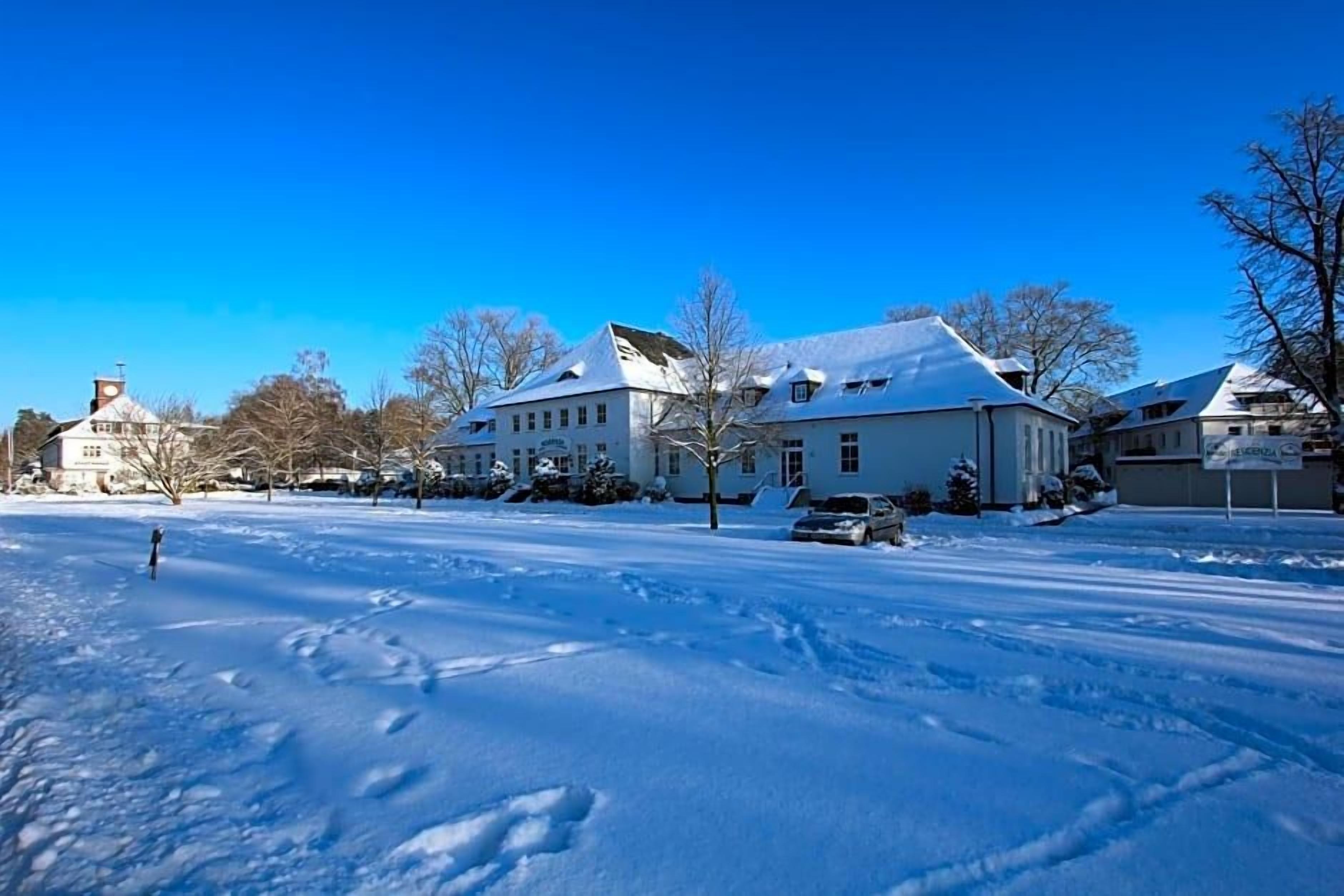 Ett snötäckt landskap med en stor byggnad som ser ut att vara ett hotell eller någon liknande anläggning.