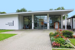 La entrada al Deutsches Panzermuseum, con un camino pavimentado y macizos de flores.