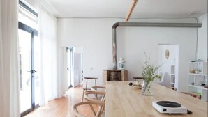A modern living room with a wooden table, a coffee table, and a small plant. There is a fireplace and a bookshelf in the background. - Beijing Migrator Mountain Resort (Changping)
