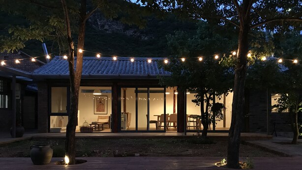 A house with a tiled roof, large glass windows, and a wooden deck. - Beijing Migrator Mountain Resort (Changping)