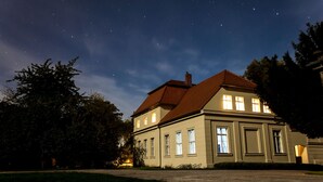 A two-story building with a red roof, multiple windows, and a well-maintained lawn. - Schloss Plaue (Brandenburg an der Havel)
