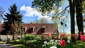 A house with a sloped roof and a stone wall in front. - Schloss Plaue (Brandenburg an der Havel)