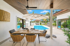 An outdoor dining area with a pool, wicker furniture, and a covered patio. - Boutique 3BR Pool Villa White Cove Rawai (Rawai)