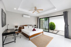 Une chambre à coucher moderne, équipée d’un lit, d’un bureau et d’un ventilateur de plafond.