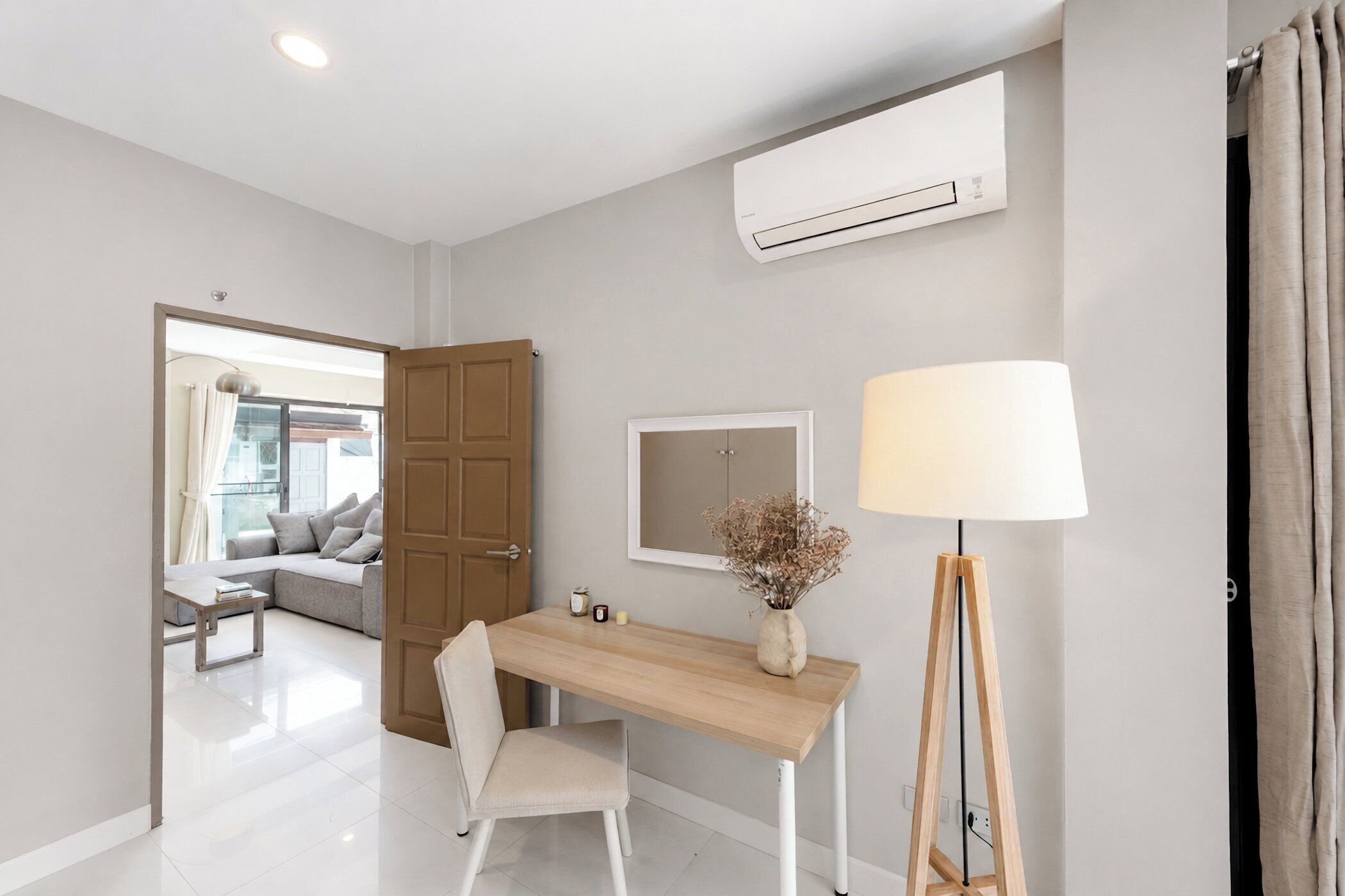 Habitación moderna con escritorio, silla, lámpara y unidad de aire acondicionado.
