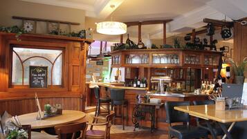 A bar area with wooden furniture, a bar counter, and various bottles and glasses.