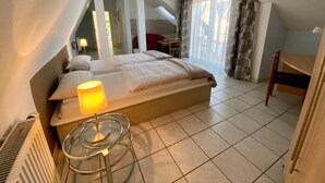 Une chambre à coucher avec un lit, une table de chevet, une lampe et une chaise.