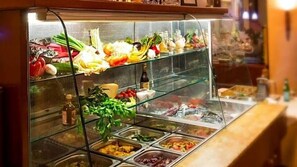 A buffet with various food items and condiments.
