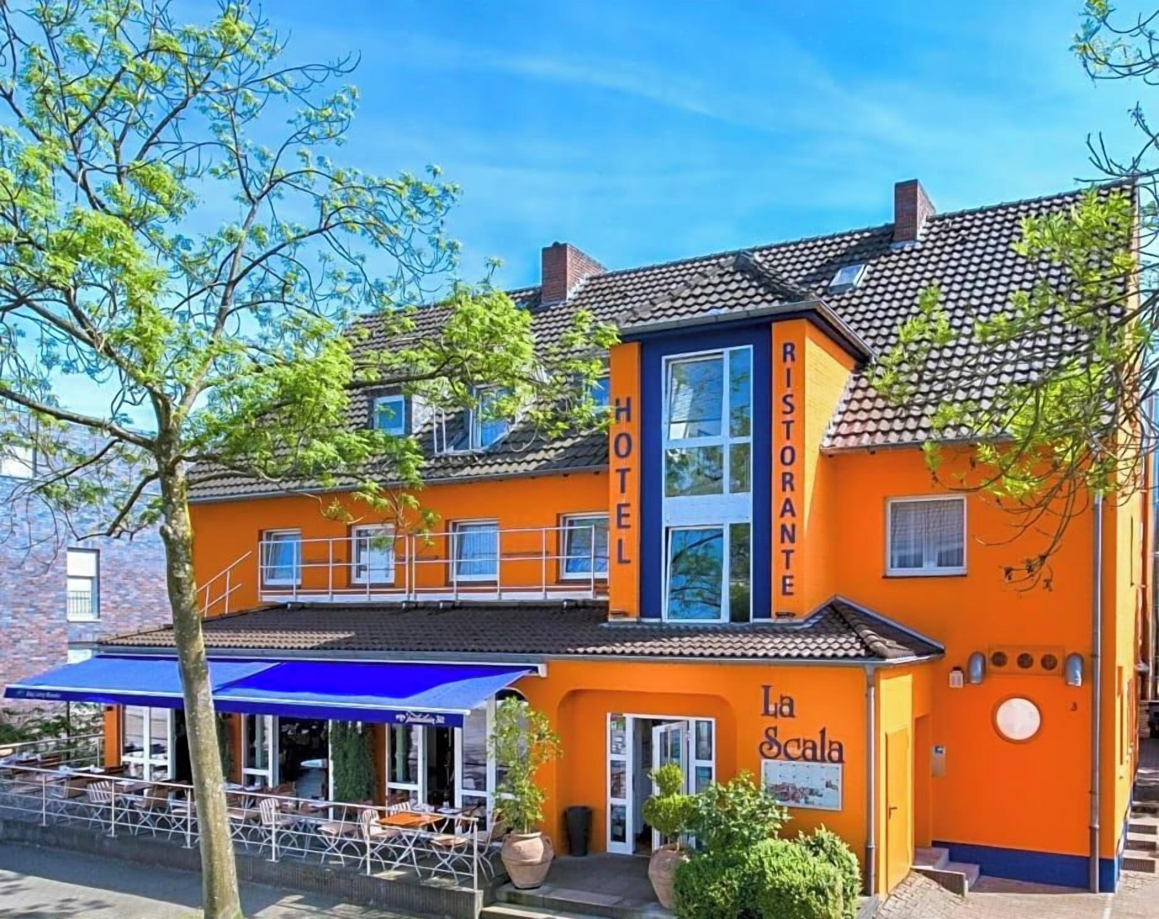 Ein Hotel mit Terrasse und Außenbereich zum Sitzen.