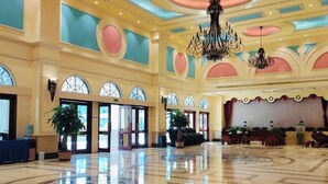 A spacious lobby with a polished marble floor, large arched windows, and a chandelier. - Lianjiang Libo Hotel (Lianjiang)