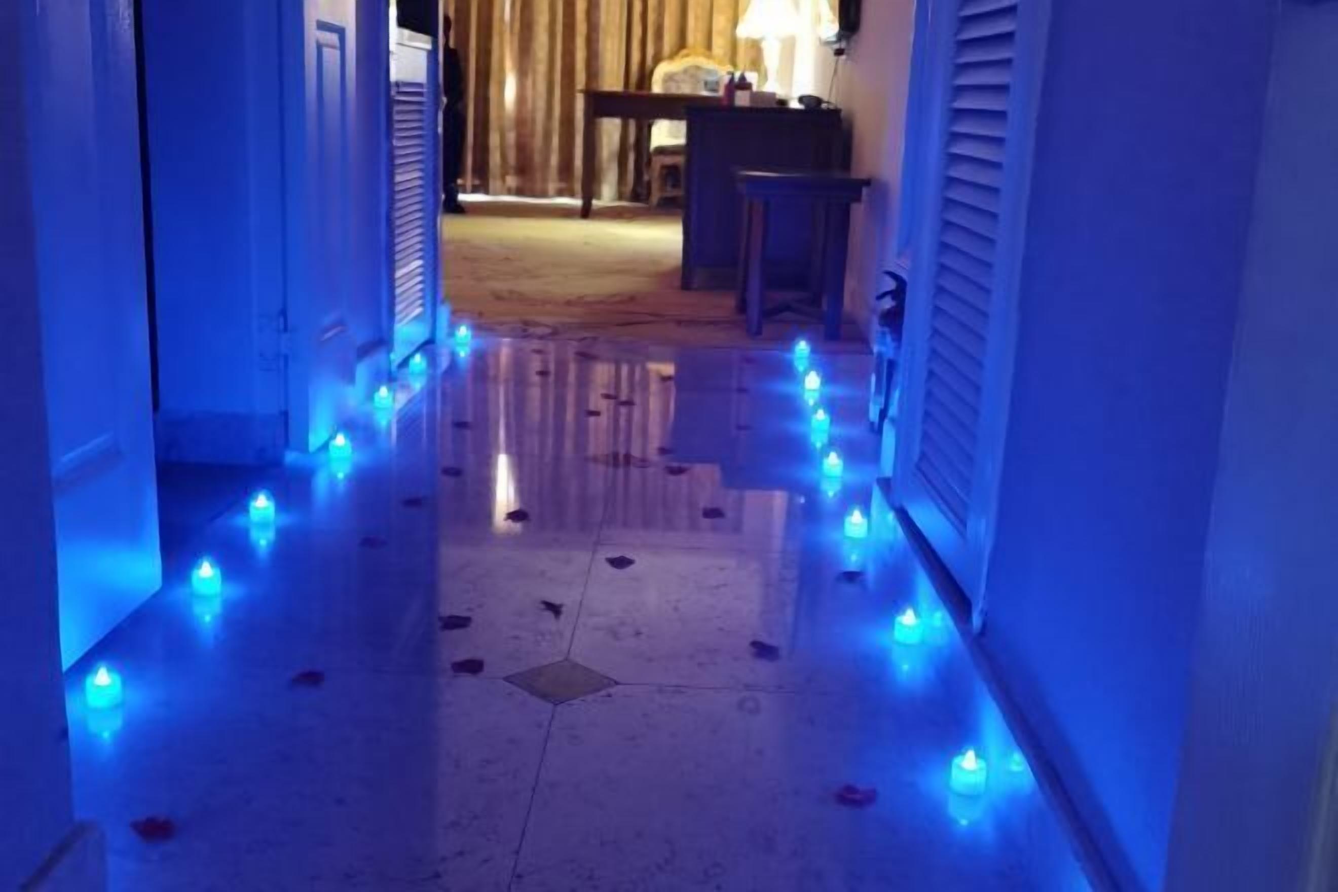 Un corridoio con pavimento lucido e illuminazione blu soffusa.