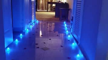 Un corridoio con pavimento lucido e illuminazione blu soffusa.