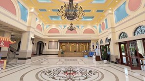 A spacious lobby with a grand chandelier, a reception desk, and a decorative floor pattern. - Lianjiang Libo Hotel (Lianjiang)