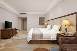A hotel room with a bed, a TV, a lamp, a telephone, and a wooden cabinet. - Lianjiang Libo Hotel (Lianjiang)