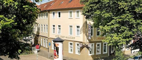 A hotel building with a sign reading 'HOTEL STADT HANOVER' and a no-entry sign visible.