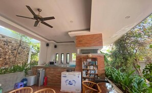 Un interior moderno con ventilador de techo, mostrador de recepción, refrigerador y estantería.