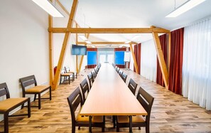 A conference room with a long table, chairs, a projector, and a whiteboard. - Alpha (Bad Langensalza)