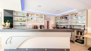 A modern bar area with glass shelves, a coffee machine, and a variety of bottles and glasses. - Alpha (Bad Langensalza)