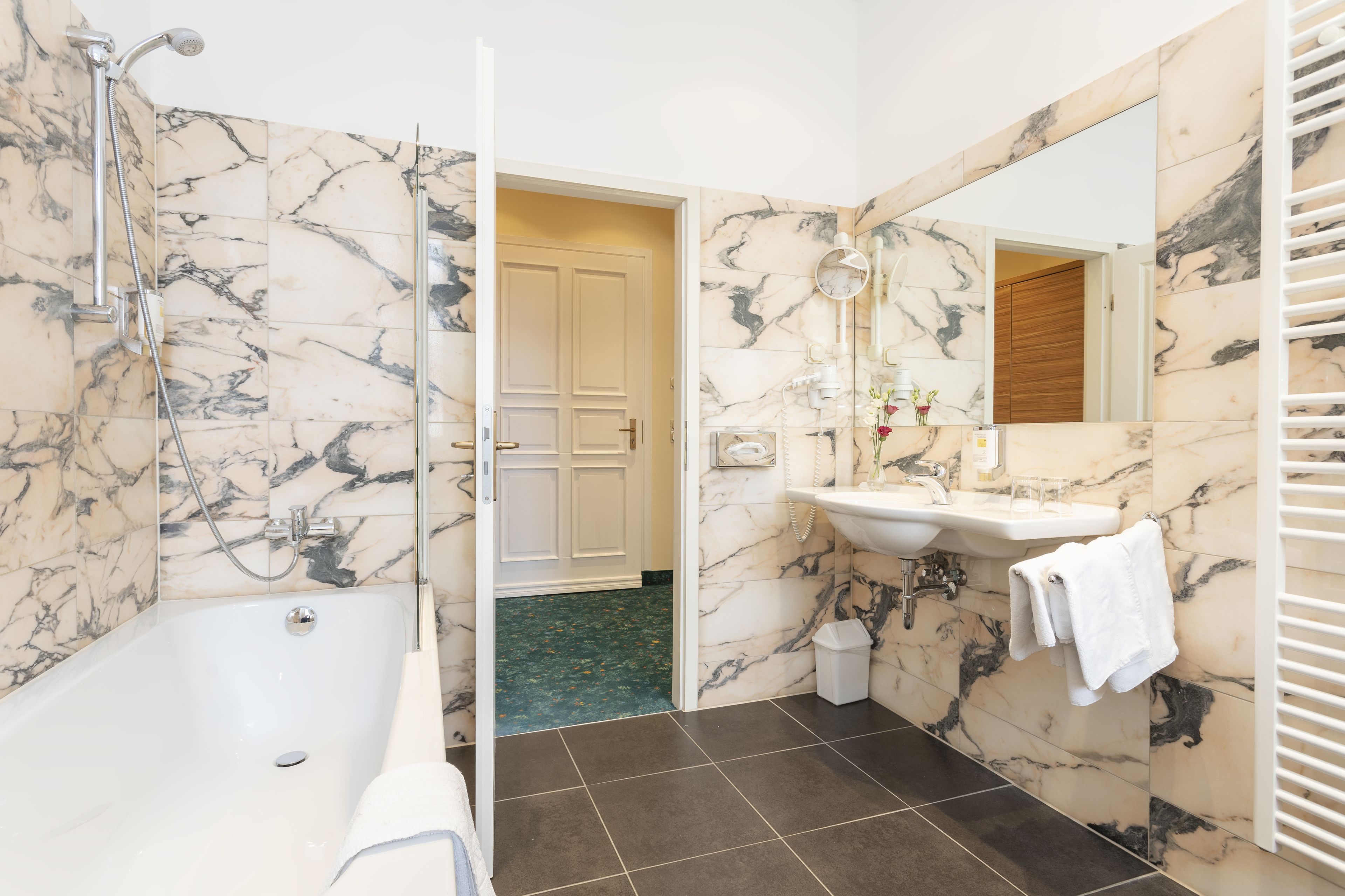 A bathroom with a bathtub, a sink, and a mirror.