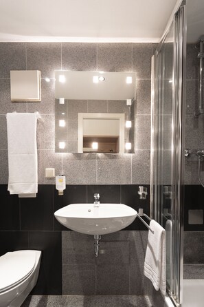 Standaard eenpersoonskamer | Badkamer | Een haardroger, handdoeken, zeep, shampoo