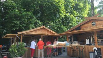 An outdoor wooden structure with a sign reading "Wurstladen Pizzeria".
