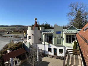 A building with a tower, a sign reading "Caststätte '5 Kontinente'", and a paved courtyard with potted plants. - Restaurant - Pension Zum Aumatal (Weida)
