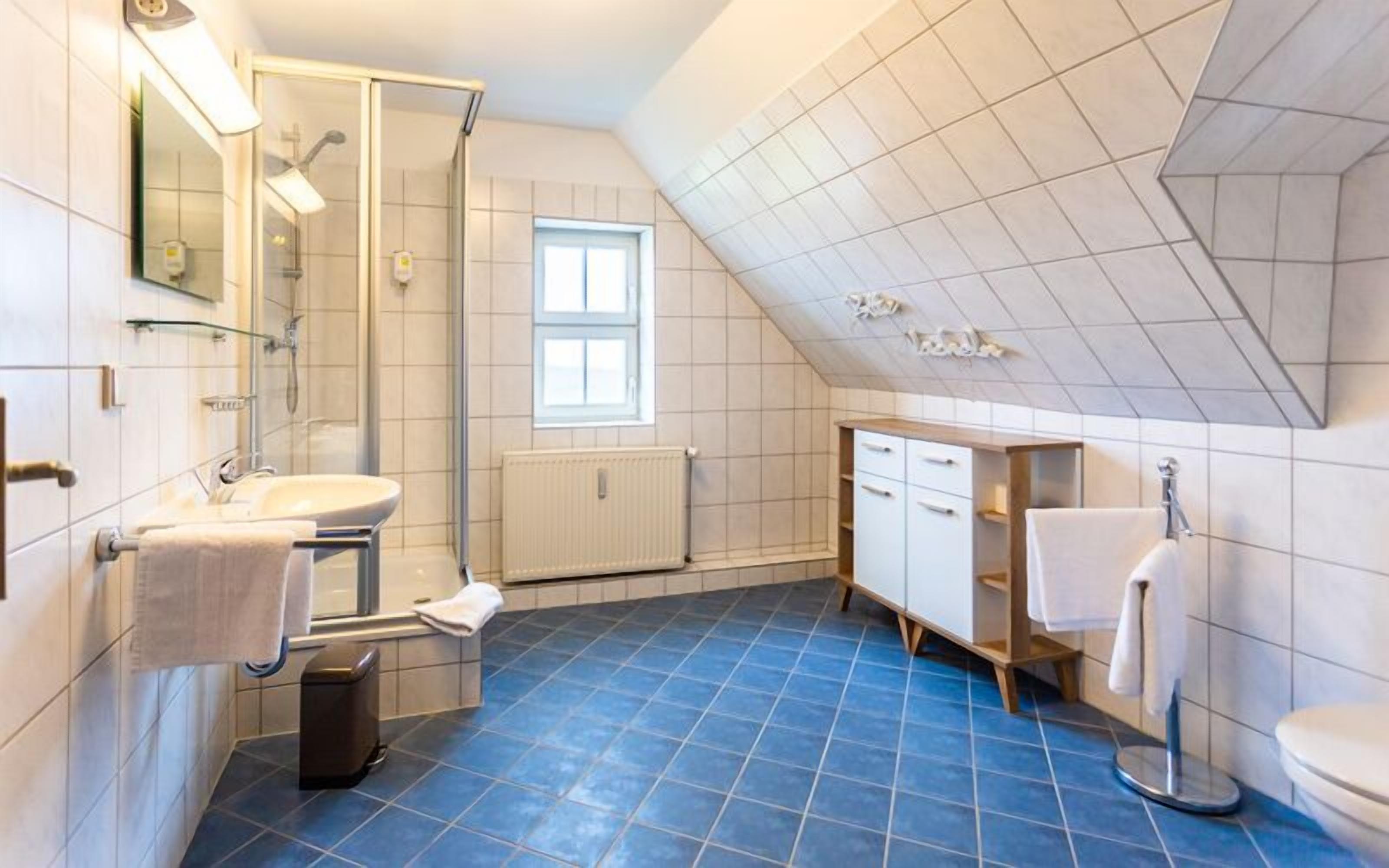 A modern bathroom with a shower, sink, and toilet.