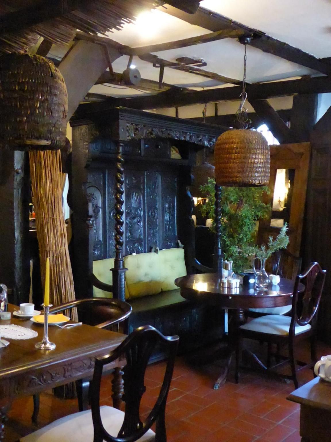 A rustic dining area with wooden furniture, a hanging light fixture, and a green plant centerpiece.