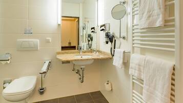 Un baño moderno con inodoro, lavabo, toallero y secador de pelo.