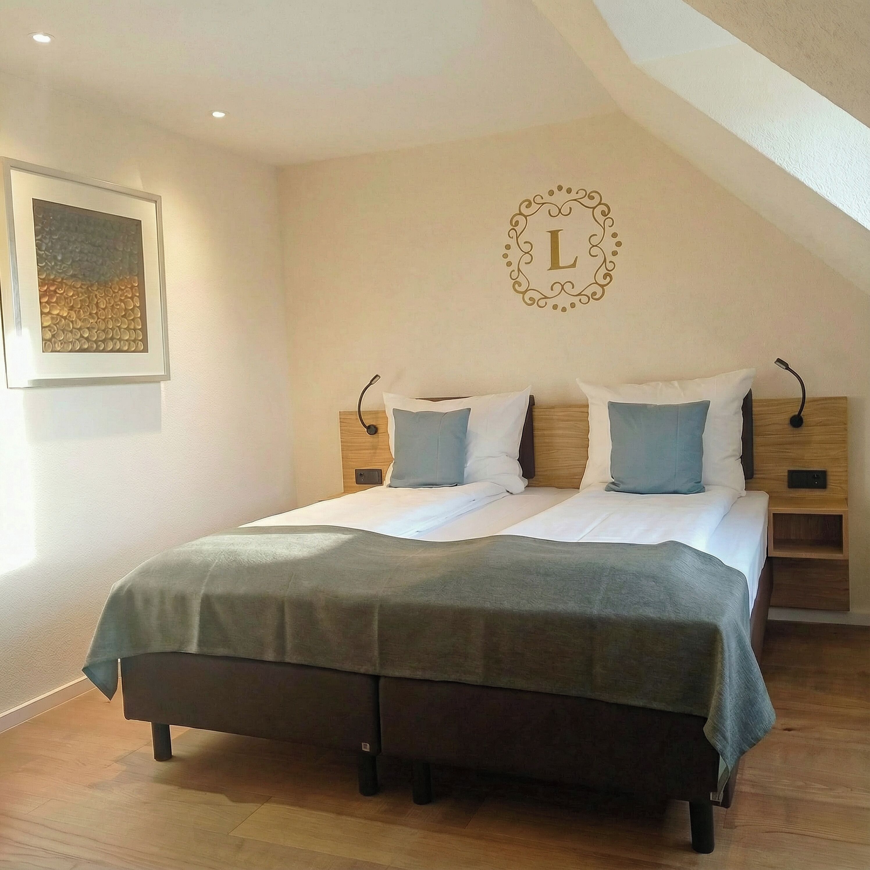Een slaapkamer met een bed, twee nachtkastjes, een wandlamp en een kunstwerk in een lijst.