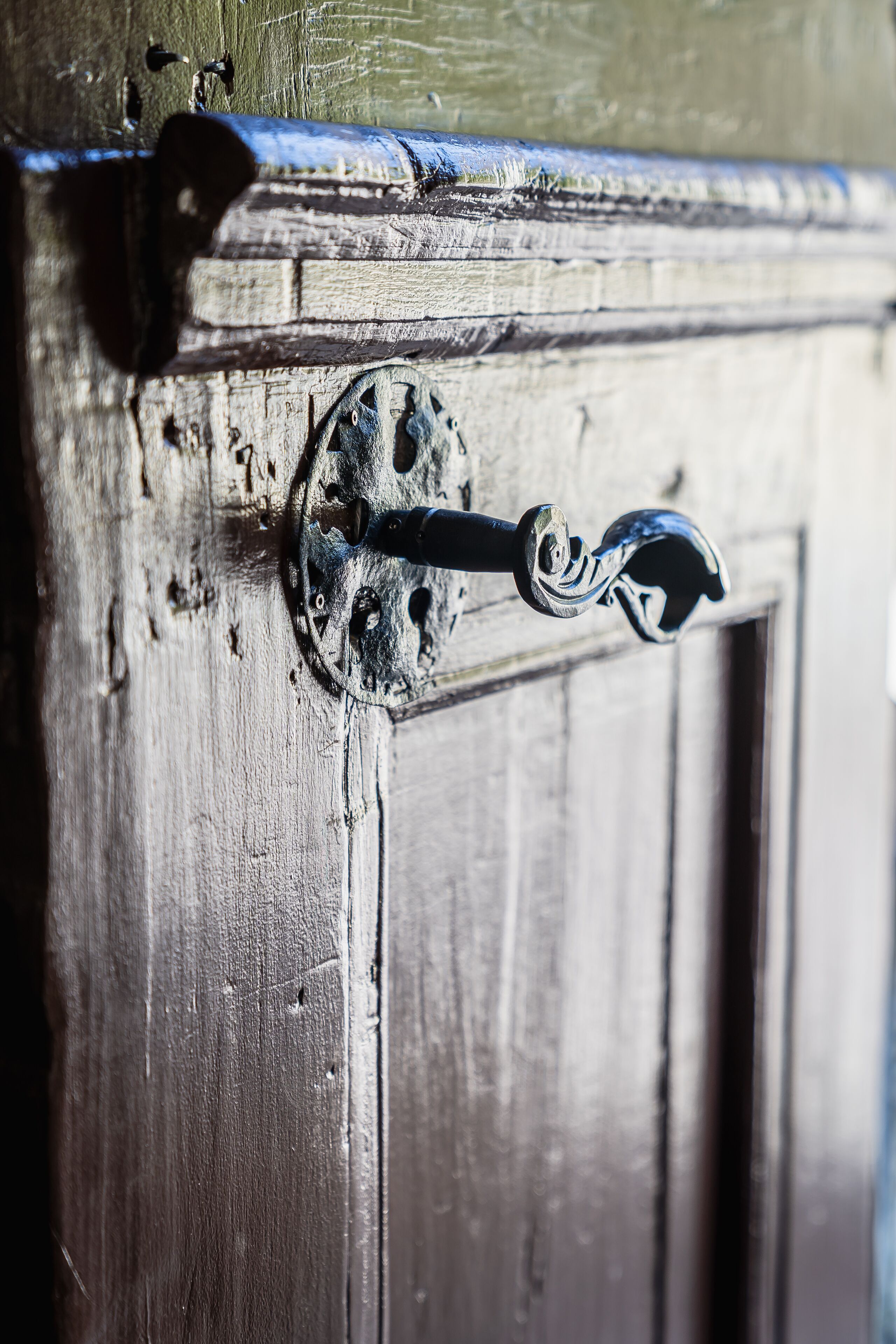 Un gros plan d’une poignée de porte, avec une plaque métallique circulaire et un trou de serrure.