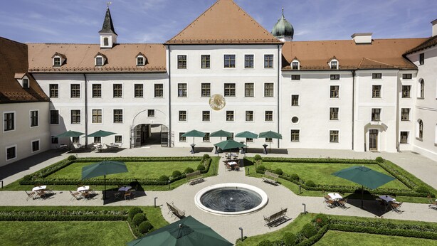 A large building with a central courtyard, multiple windows, and a fountain. - Kloster Seeon (Seeon-Seebruck)