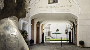 An entrance to a building with an arched doorway and a sign reading "Kloster Seeon Kultur u. Bildungzentrum." - Kloster Seeon (Seeon-Seebruck)