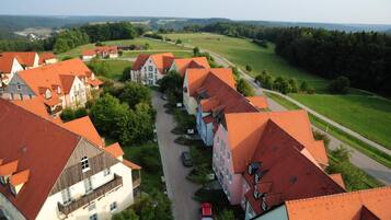 A residential area with houses featuring red-tiled roofs and a central road.