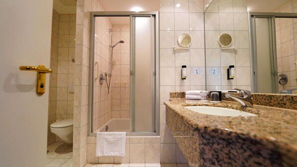 Un bagno d'albergo con doccia, WC e lavandino.