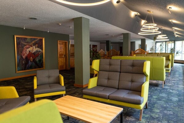 A hotel lobby with seating areas, artwork on the walls, and a carpeted floor. - Gut Matheshof BW Signature Collection (Rieden)