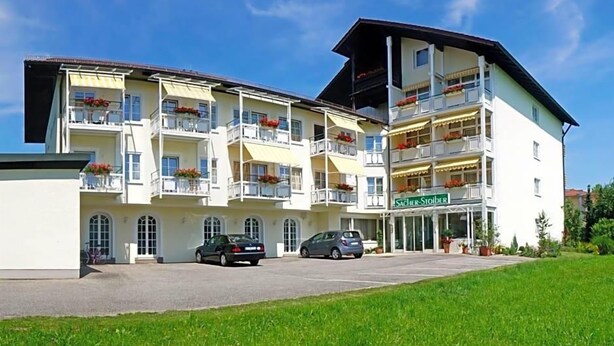 A multi-story hotel with balconies, a sign reading 'Südler-Stöder,' and cars parked in front. - Hotel Sacher Stoiber (Bad Fuessing)