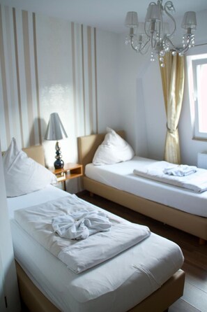 A hotel room with a bed, bedside table, lamp, and a chandelier. - Hotel Zum Wersehof (Ahlen)