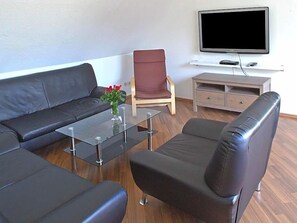 A modern living room with a sofa, armchair, and a coffee table.