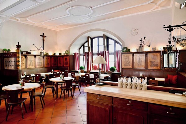 Ein Restaurantinneres mit mehreren Tischen, Stühlen und einer Bar.