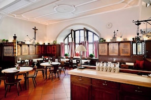 Un interior de restaurante con varias mesas, sillas y una zona de bar.