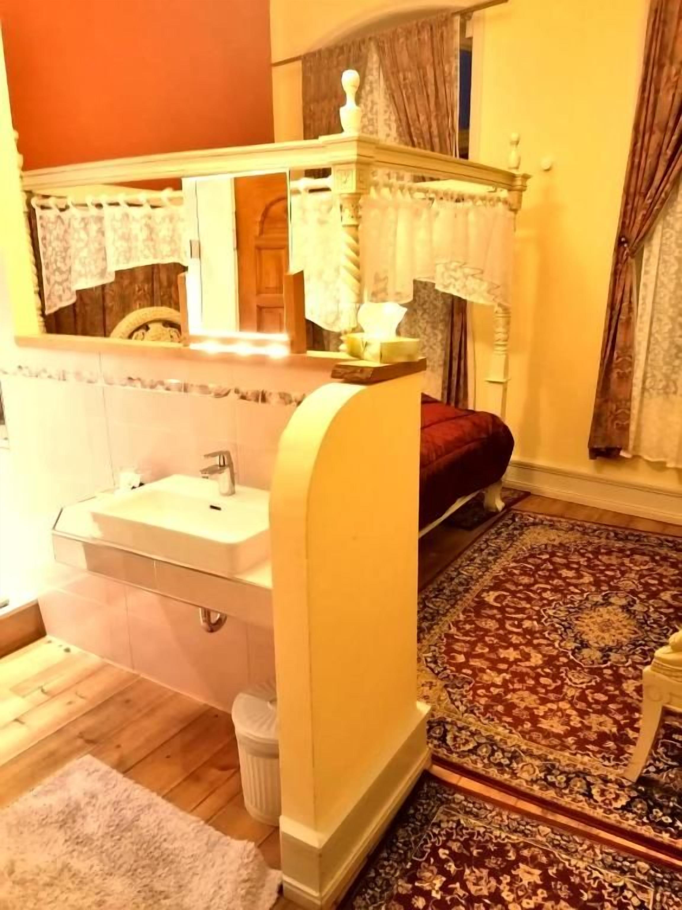 Une salle de bain avec un lavabo, un miroir et un tapis à motifs.