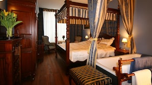 Una cama con dosel, muebles de madera y un jarrón con flores.