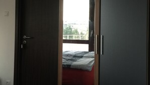Une chambre avec un lit, une armoire et une fenêtre.