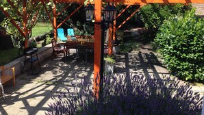 Une structure de pergola en bois, avec une table et des chaises en dessous.